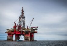 red and grey oil platform in sea