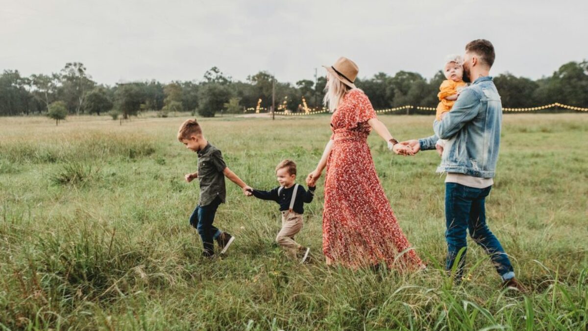 woman holding man and toddler hands during daytime