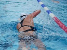 woman in black and white bikini swimming on pool during daytime