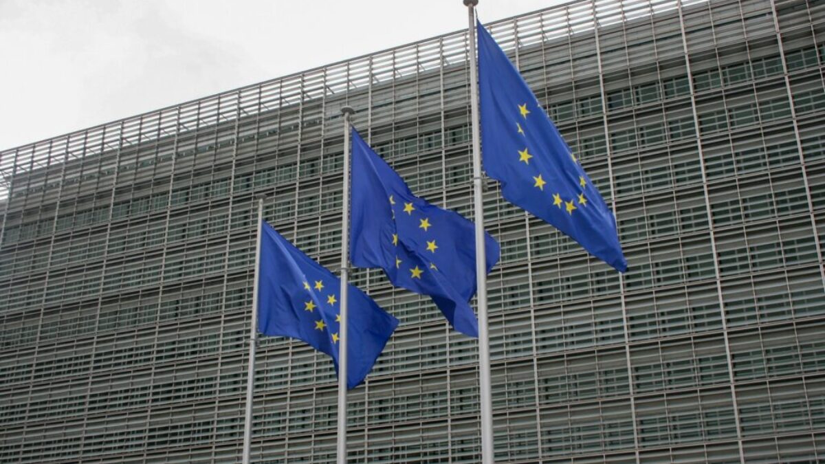 three european flags flying in front of a building