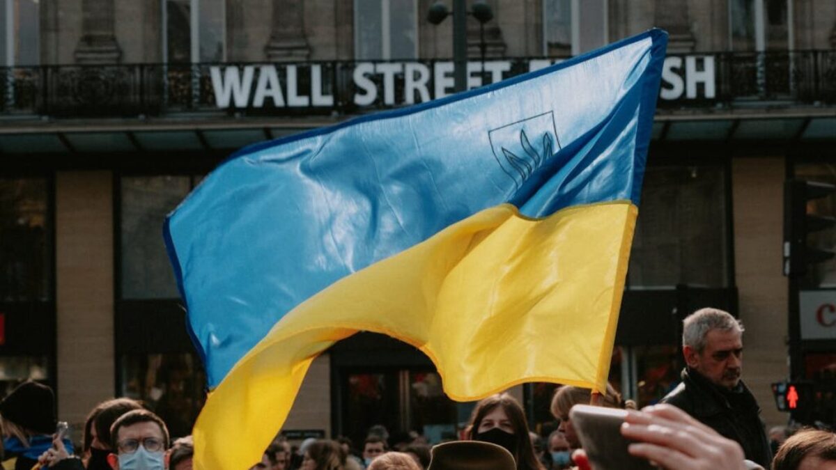 Blue and yellow Ukrainian Flag Waving Above Crowd of People
