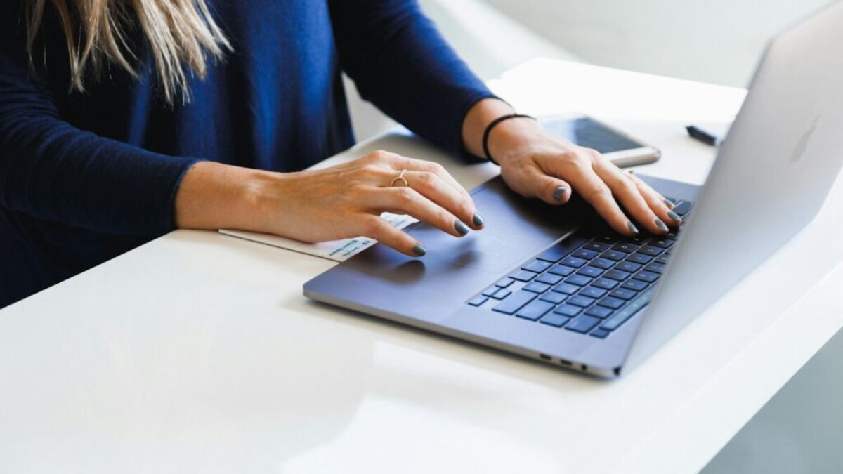 woman in blue long sleeve shirt using macbook pro