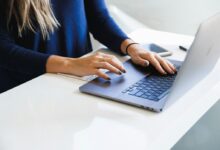 woman in blue long sleeve shirt using macbook pro