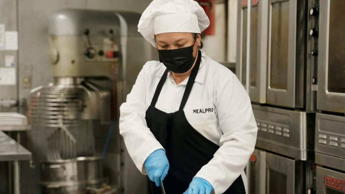 chef holding green and yellow plastic tray
