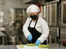 chef holding green and yellow plastic tray