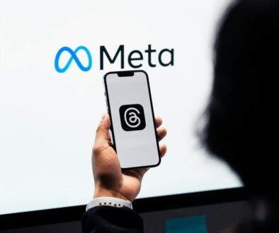 a person holding a cell phone in front of a large screen