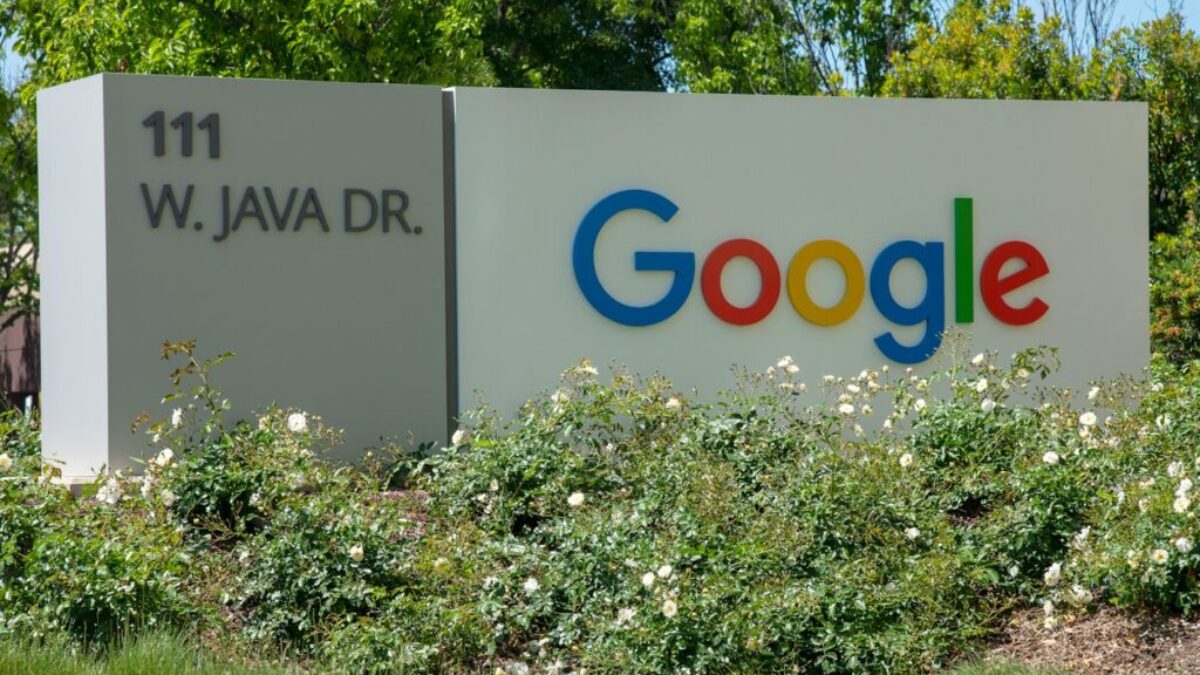 a google sign in front of some bushes and trees