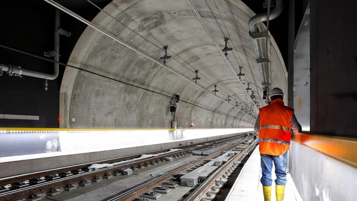 man standing beside train rail