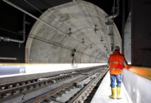 man standing beside train rail