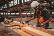 man in orange and black vest wearing white helmet holding yellow and black power tool