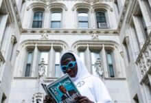 man in white thobe holding book