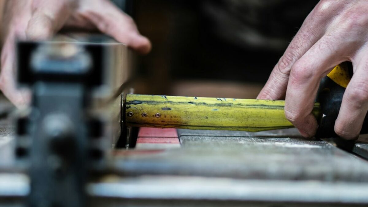 person holding yellow steel measuring tape in closeup photo