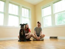 woman in gray shirt sitting on brown wooden floor