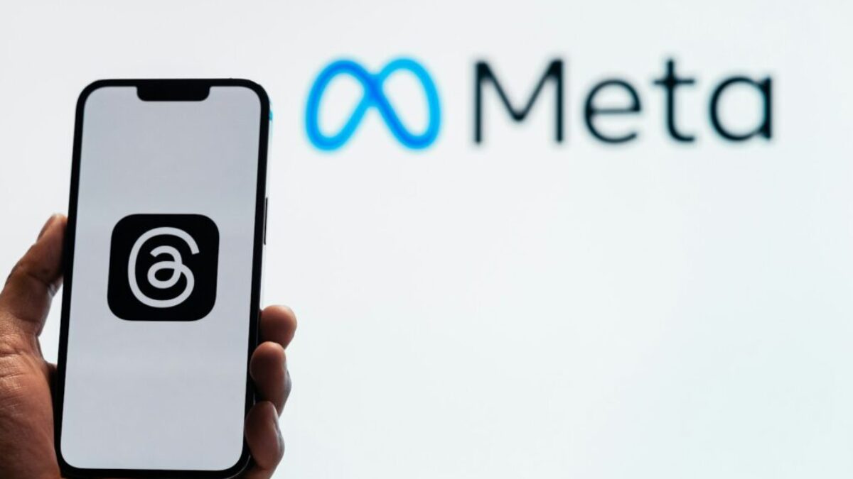 a person holding up a cell phone in front of a sign