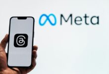 a person holding up a cell phone in front of a sign