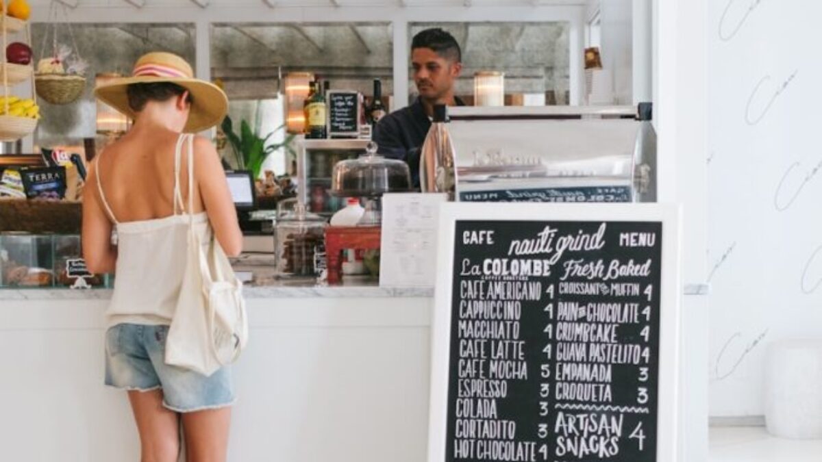 woman with white spaghetti strap top near the bar