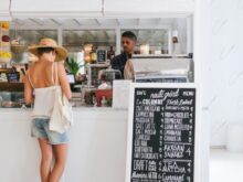 woman with white spaghetti strap top near the bar