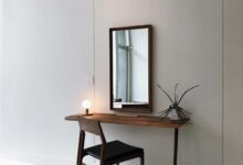 black leather chair with brown wooden frame in front of half table