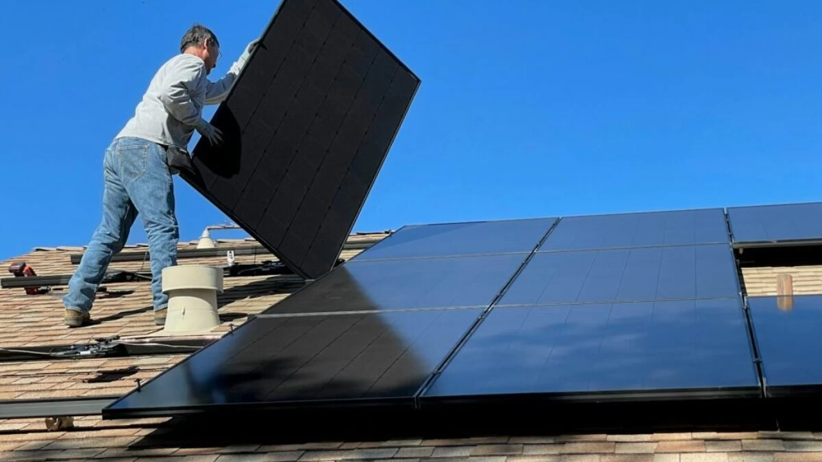 man in white dress shirt and blue denim jeans sitting on white and black solar panel