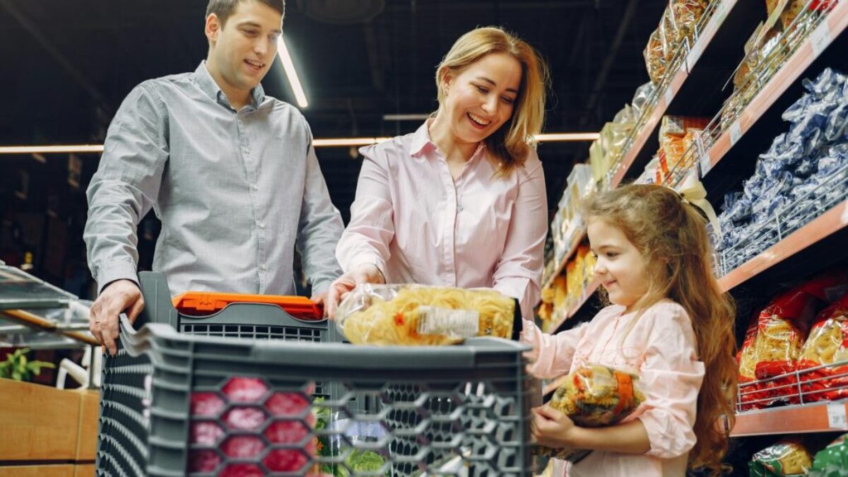 A joyful family of three shopping together in a supermarket, creating a memorable experience.
