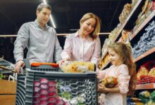 A joyful family of three shopping together in a supermarket, creating a memorable experience.