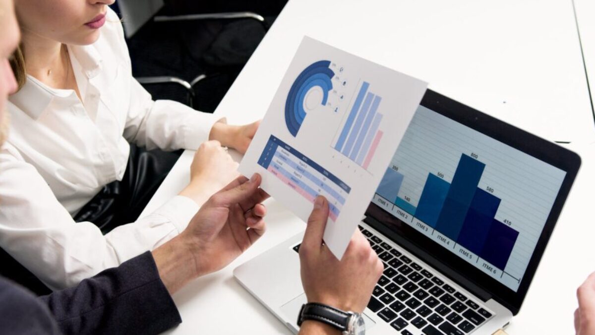 Business professionals discussing data charts and graphs in a modern office setting.