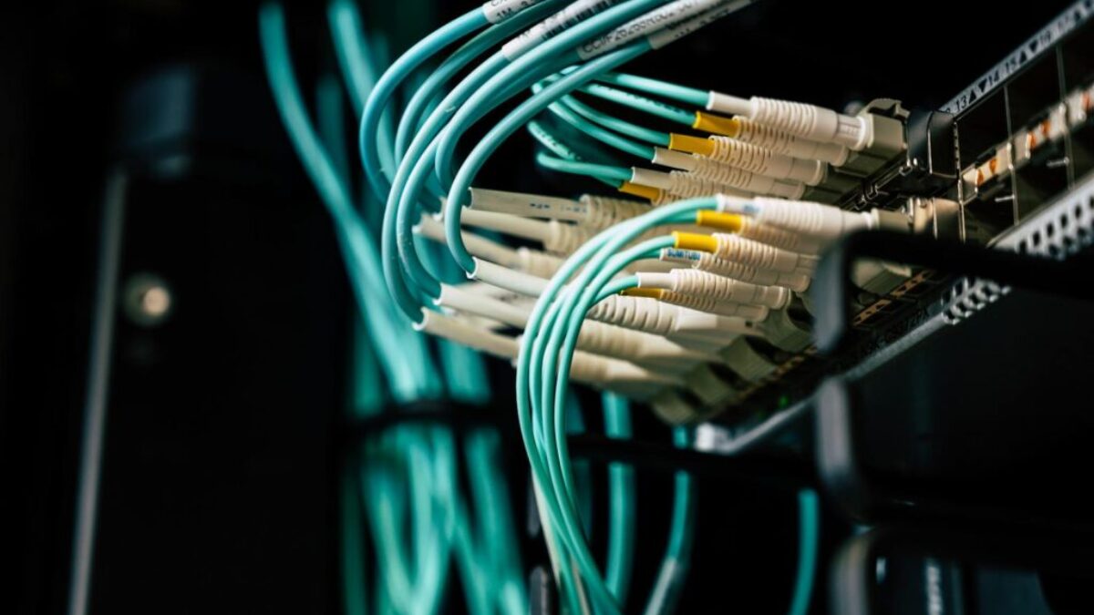 Detailed view of network cables plugged into a server rack in a data center.