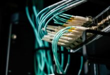 Detailed view of network cables plugged into a server rack in a data center.