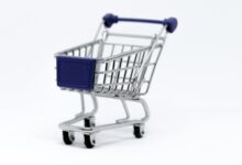 A modern miniature shopping cart on a clean white background, perfect for e-commerce concepts.