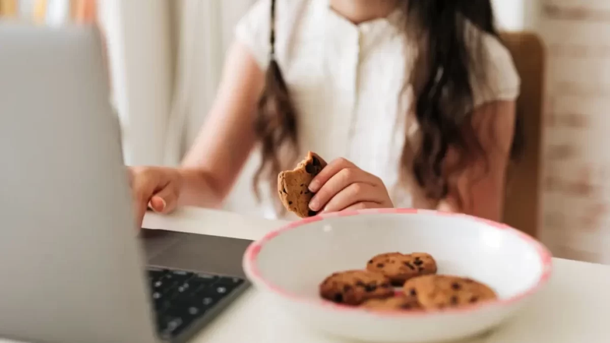 Žena hledá informace na internetu a současně jí sušenky, cookies.