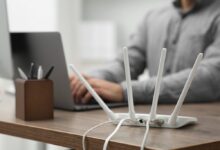 Router se čtyřmi anténami a člověkem v pozadí, zdroj: Shutterstock