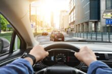 Muž řídí motorové vozidlo a drží volant