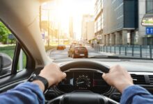 Muž řídí motorové vozidlo a drží volant