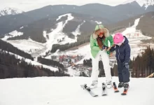 Matka s dcerou lyžuje v horském středisku.