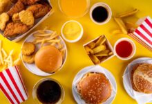 Hamburgery, maso a omáčky z rychlého občerstvení na stole