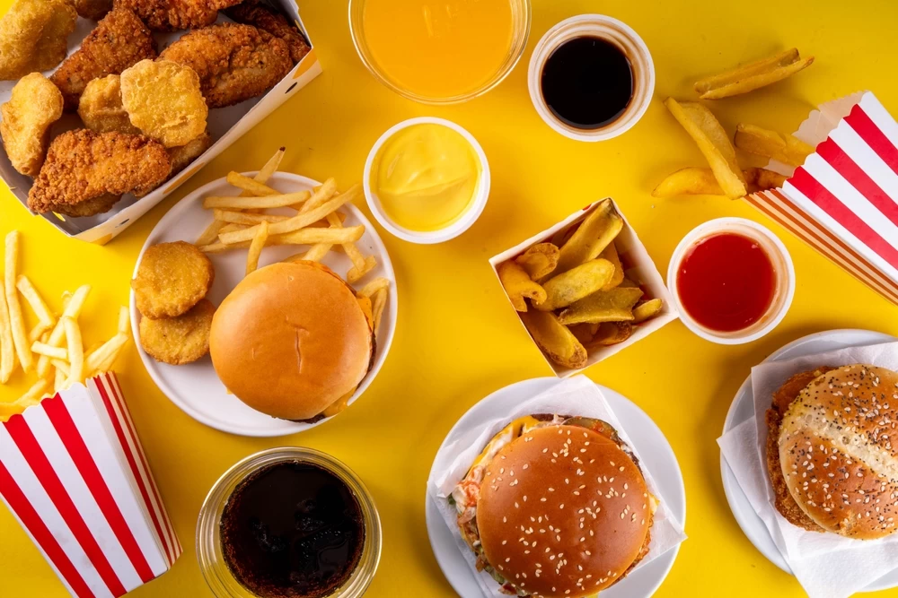 Hamburgery, maso a omáčky z rychlého občerstvení na stole