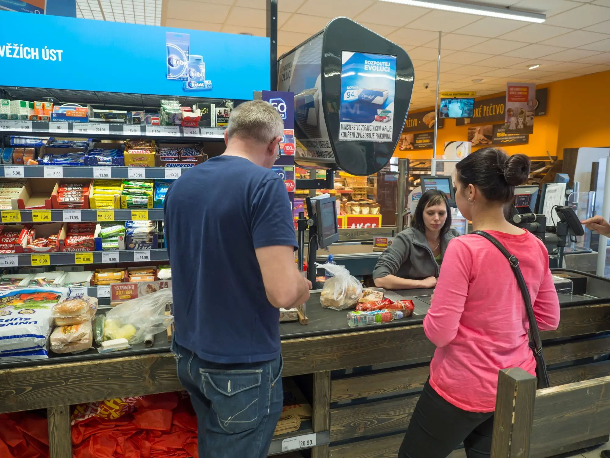 Shutterstock_1425858302 - ByznysDeník Muž a žena platící na pokladně PENNY Marketu