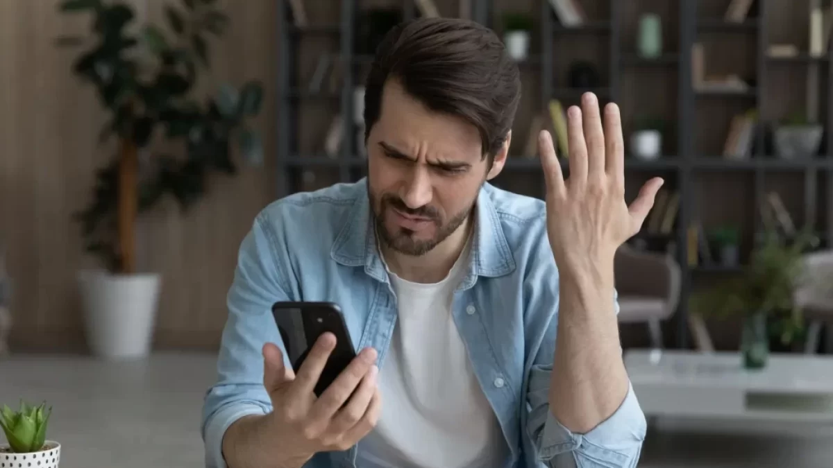Rozčarovaný muž s mobilním telefonem v ruce
