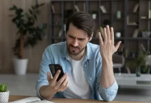Rozčarovaný muž s mobilním telefonem v ruce