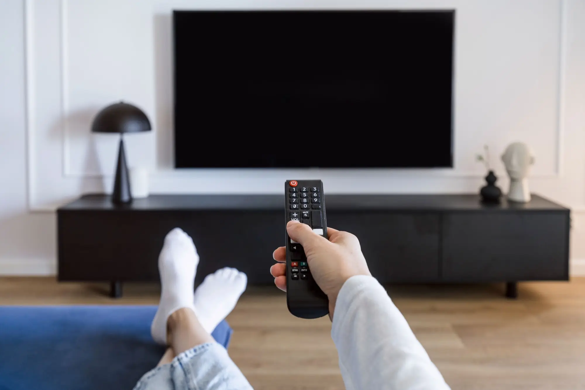 Shutterstock_2443242693 - ByznysDeník Zapínání televize ovladačem z gauče