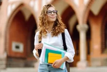 Studentka s kudrnatými vlasy držící knihy