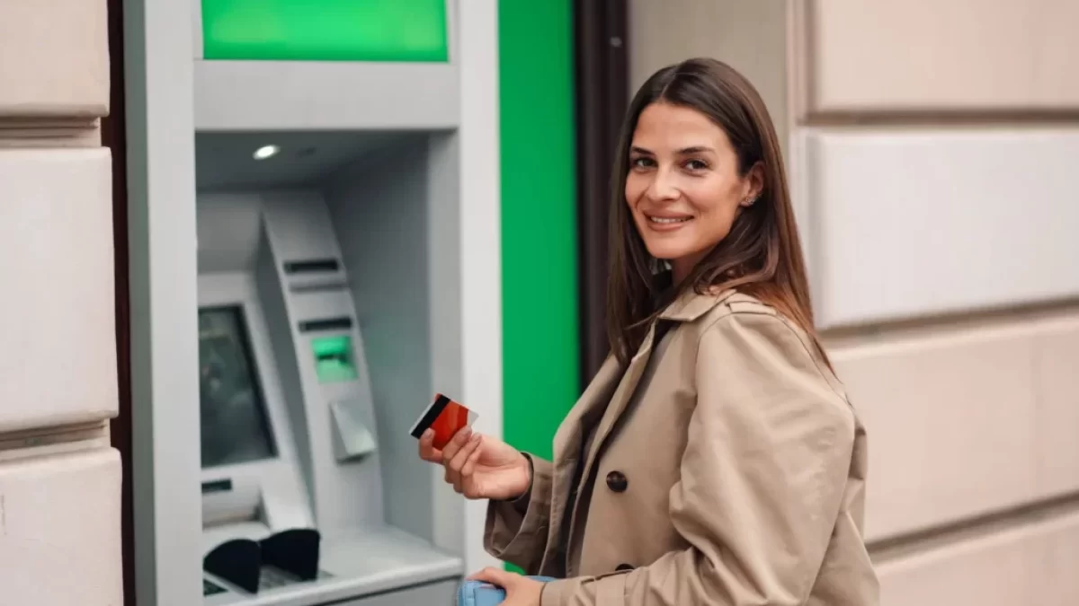 Žena stojící u bankomatu