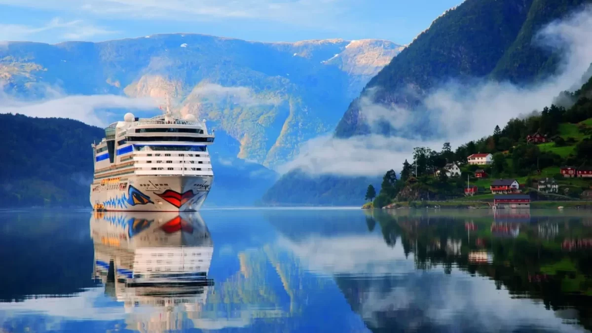 Luxusní loď pluje mezi norskými fjordy, obklopená krásnou přírodou.