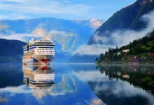 Luxusní loď pluje mezi norskými fjordy, obklopená krásnou přírodou.