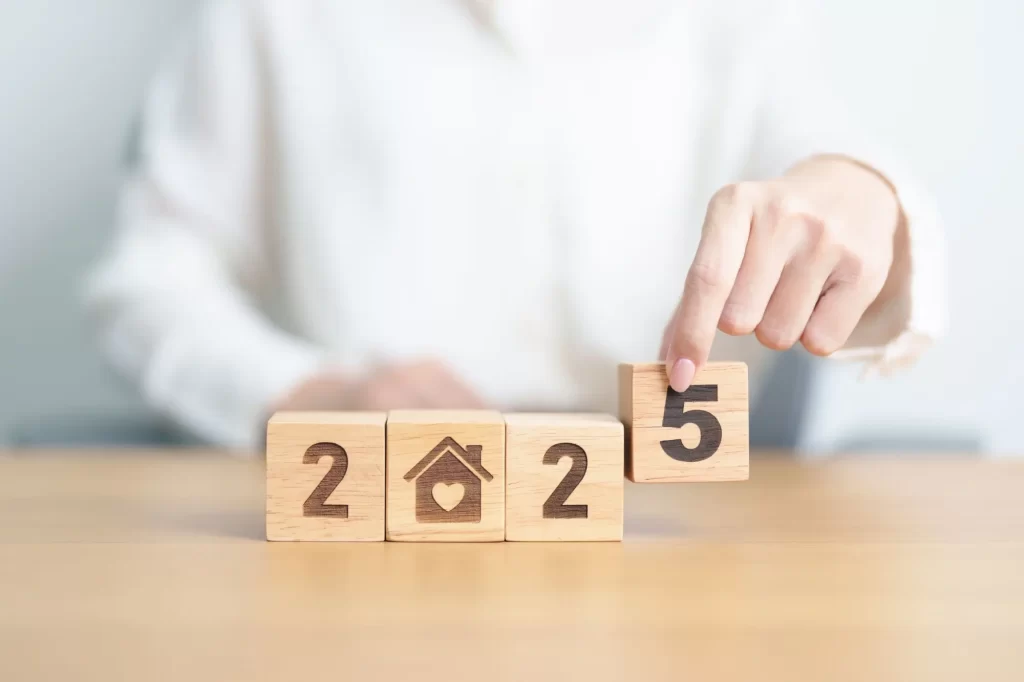 Shutterstock_2534630851 - ByznysDeník Dřevěné kostky zobrazující rok 2025, přičemž na jedné z kostek je symbol domu,