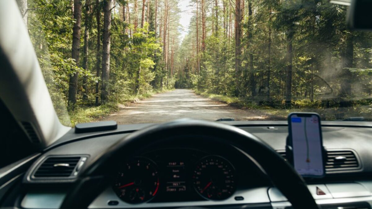 Palubní deska a volant v autě, výhled na cestu