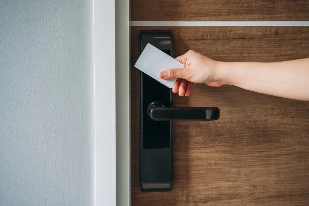 Moderní doba nabízí alternativní možnosti, např. digitální zámek otevíraný čipem, zdroj: Shutterstock.com - ByznysDeník Žena otevírá dveře čipem/kartou