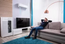 Muž sedí na gauči u televize.