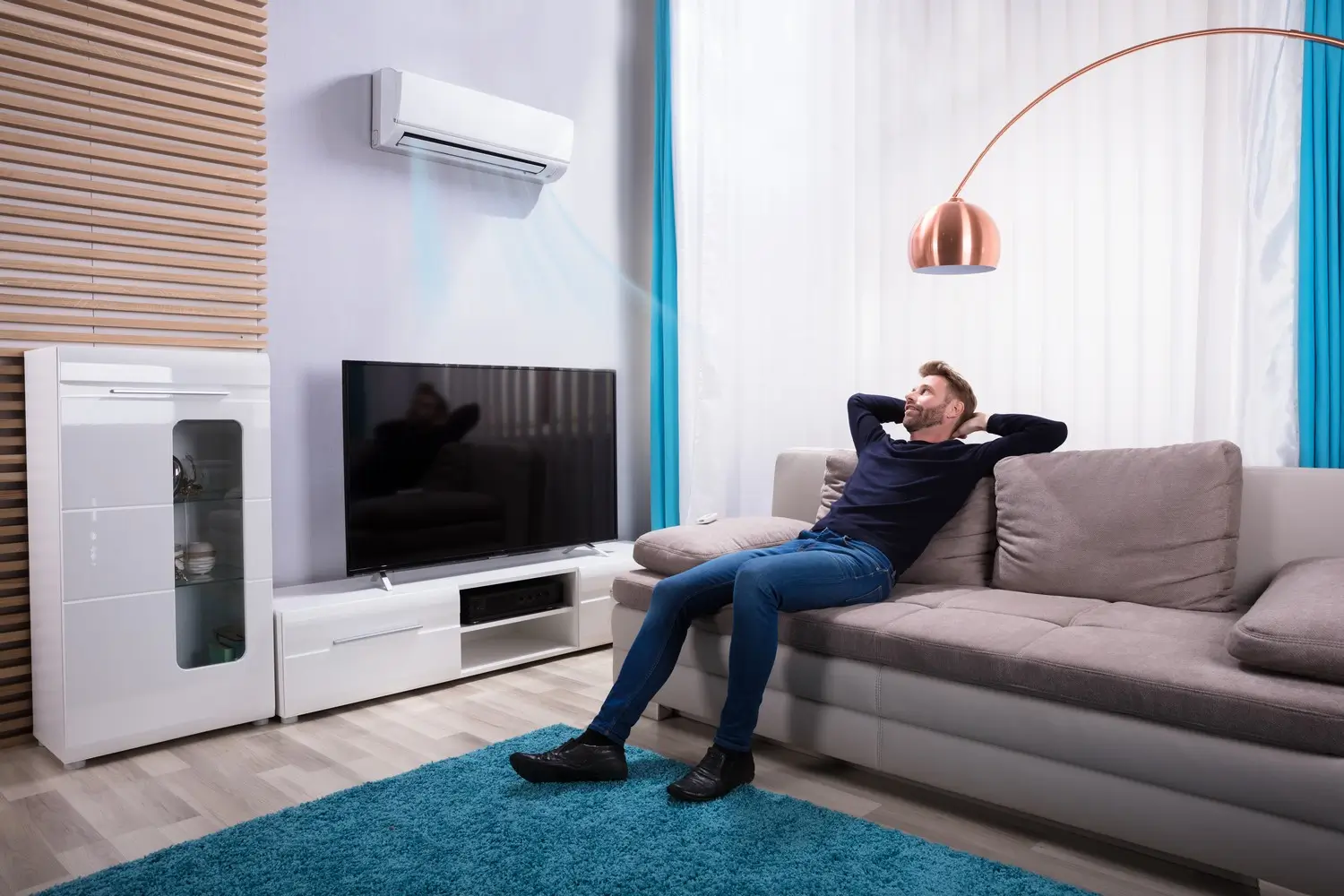 Muž sedí na gauči u televize.