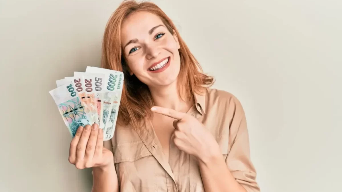 Žena ukazující na české bankovky